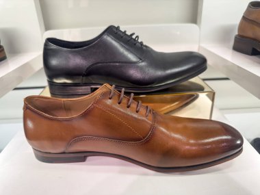Butiğin rafında şık deri erkek ayakkabıları satılıyor. Erkek modası