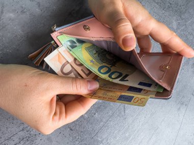 Kadın cüzdanına ya da amcık parasına 50 bin dolar koyuyor. Tasarruf kavramı. Faturalar.