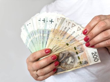 Polonyalı zloti banknotları yığını beyazdan izole edilmiş alışveriş için kadın elini tutuyor. Para finansal konsepti