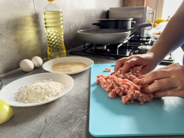 Mutfaktaki kadın, çiğ etten ev yapımı pirzola ya da pelmeni hazırlıyor. Pişmemiş çiğ yemek.