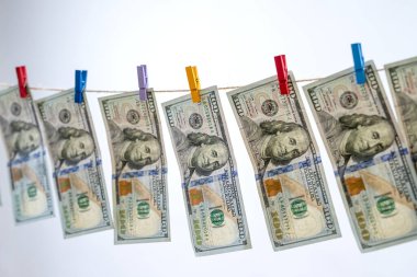 Gride izole edilmiş bir ipte 100 dolar asılı. Çamaşır yıkamama kavramı. 