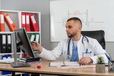  Doktor bey masamızda oturup dizüstü bilgisayarını kullanarak tıbbi temalar ve işyeri eğitimi alıyor. Sağlık personeli