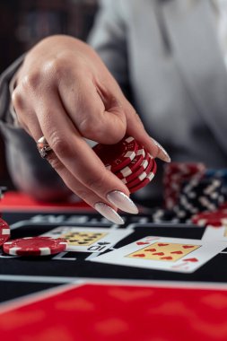 Kadın oyuncu poker oynar ve bahsi arttırmak için fiş alır. Kumarhane oyunu