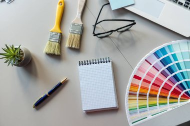 Fırçalı basım için renk paleti rehberi, ofis masasında boş not defteri. Yaratıcı işyeri