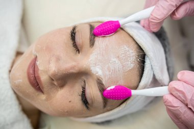 Güzellik uzmanı güzellik salonunda kadın müşterisine yüz bakımı yapıyor. Bakım konsepti 