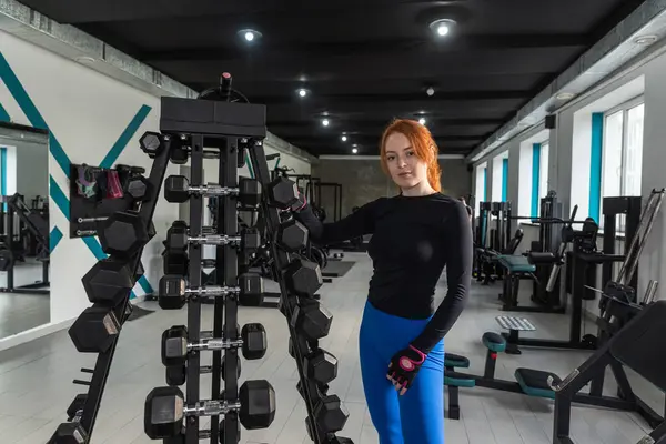 stock image pretty woman doing training exercises in her arms biceps and triceps with dumbbell in fitness center