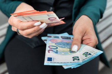 10 tane 20 Euro 'luk banknot tutan kadın. Finans kavramı veya tasarruf ödemesi 