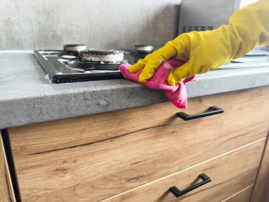 Temizlikçi, ahşap mutfağı temizlemek için bez kullanıyor. İyi hijyen için dezenfekte çözümleri