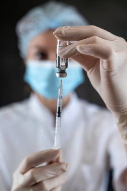caucasian woman doctor on nurse in full medical uniform prepare syringe with medication for vaccine isolated. Vaccination and immunization concept