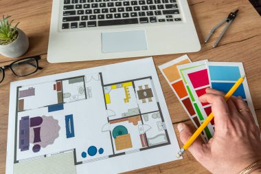 Renk paletli ev planı yapmak için dizüstü bilgisayar, ofis masasında mimari planlar. Emlak kavramı, ev dekorasyonu.