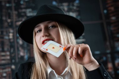 Genç beyaz kadın kırmızı dudakların yakınında as tutuyor. Poker