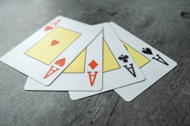 Gri arkaplanda kağıt oynayan dört as. Kumarhanede poker oyunu. Kumar konsepti