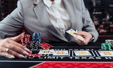 Kumarhanede poker oynayan takım elbiseli, heyecanlı bir iş kadını. Gece hayatı.