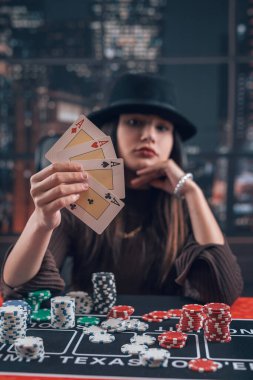 Profesyonel bayan oyuncu as tutarak poker oyununda kazanma kombinasyonu olarak kart oynuyor. Bahis ve para kazanıyor.