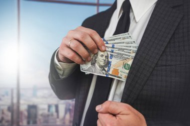 Businessman wear suit receive bribe and putting dollars money in pocket, corruption concept
