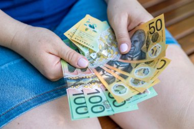 Kadın yeni 50 AUD Avustralya Doları finansal konseptini sayıyor. Kaydediliyor
