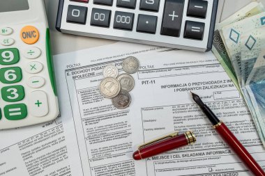 Polonyalı vergi formlarını PIT-11 'le doldurmak. Masaya kalem parasıyla dolma kalemler, vergi kağıtları. Muhasebe kavramı