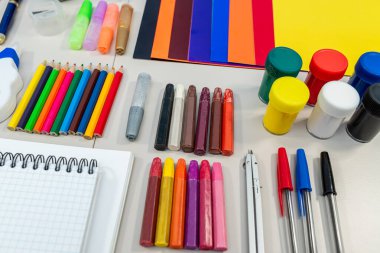 Beyaz masa arkasında farklı okul malzemeleri var. Okul konseptine geri dönelim. Düzey Kompozisyon Eğitimi