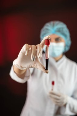 Kan örnekleriyle tüp analizi yapan bir kadın ya da biyokimya uzmanı. Sağlık personeli 