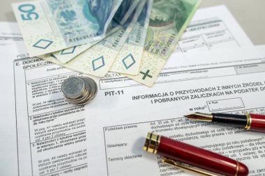 Gelir vergisi formu PIT-11 'den elde edilen gelir. Ofis masasında dolma kalemle zloti para. PIT vergisi ödeme kavramı