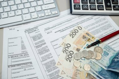 Polonyalı vergi formlarını PIT-11 'le doldurmak. Masaya kalem parasıyla dolma kalemler, vergi kağıtları. Muhasebe kavramı