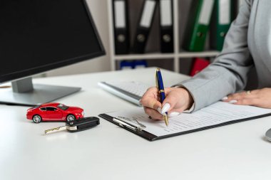 Kadın yönetici satış ofisinde araba almak ya da dinlenmek için evrakları imzalamaya hazırlanıyor. Araba finansmanı ve sigorta konsepti