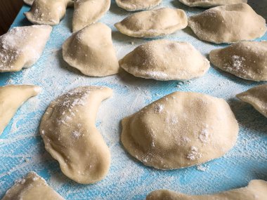 Pişmemiş Ukrayna Vareniki mantı tortellini unu. Patates ve soğandan yapılmış. Çiğ geleneksel ev yapımı yemekler.