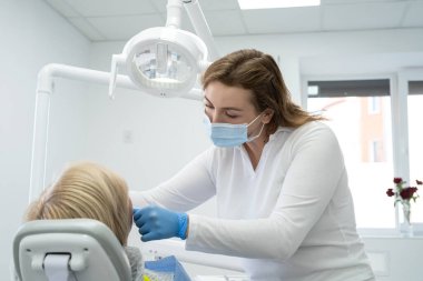 Dişçi randevusundaki emekli bir kadın. Diş muayenesi ve tedavisi