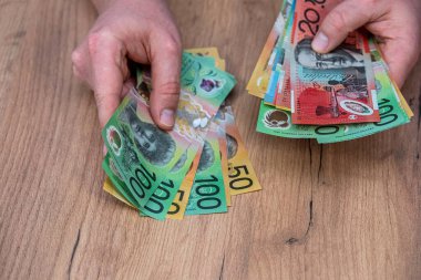 Avustralya dolarlarını sayan adam döviz banknotlarını sayıyor. 50 100 Yeni Avustralya Doları