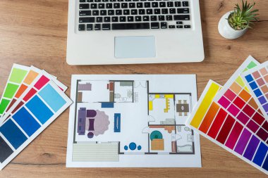 Renk paletli ev planı yapmak için dizüstü bilgisayar, ofis masasında mimari planlar. Emlak kavramı, ev dekorasyonu.