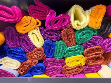 Moda ve tasarım endüstrisi için mükemmel, çeşitli renk ve malzemelerden oluşan çeşitli tekstil ruloları..