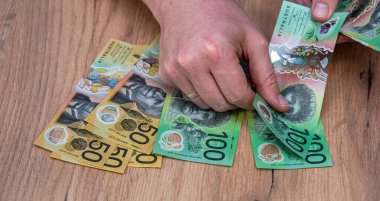 Avustralya dolarlarını sayan adam döviz banknotlarını sayıyor. 50 100 Yeni Avustralya Doları