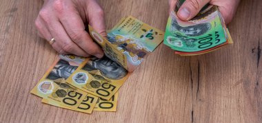 Avustralya dolarlarını sayan adam döviz banknotlarını sayıyor. 50 100 Yeni Avustralya Doları