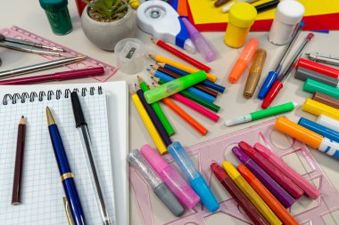 Masa, öğrencilere çeşitli eğitim ihtiyaçlarını etkili bir şekilde karşılamayı amaçlayan çeşitli temel okul malzemeleri içeren titizlikle düzenlenmiş.