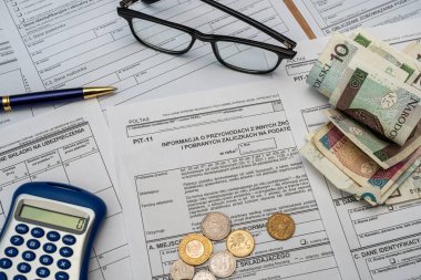 Polonya deklarasyonu PIT-36L, PIT-37 ve PIT-38 vergi formları. Masasında da pln zloty para kalem hesap makinesi gözlükleri var. Ticari vergilendirme kavramı