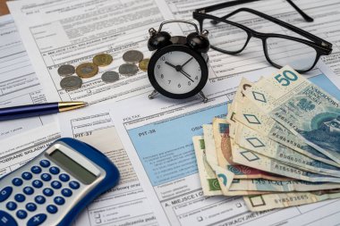 Polonya deklarasyonu PIT-36L, PIT-37 ve PIT-38 vergi formları. Masasında da pln zloty para kalem hesap makinesi gözlükleri var. Ticari vergilendirme kavramı