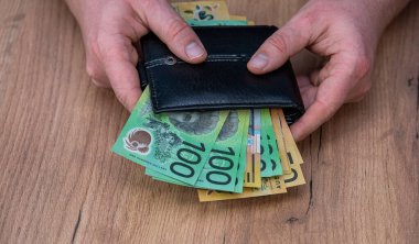 Adam Avustralya dolarlarını sayıp siyah bir cüzdan almış. Yeni para