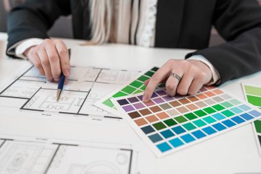 Tasarımcı elleri ofis masasındaki evin wirh renk paleti ve mimari planında çalışıyor. Yaratıcı plan planlama konsepti