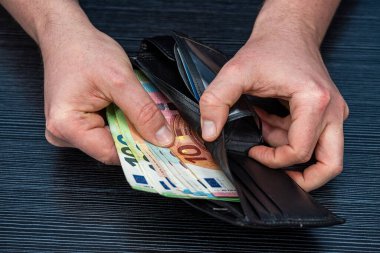 Avro ile cüzdan veren ve para sayan bir adam, tasarruf kavramı