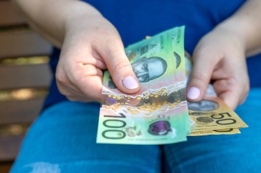 Kadın yeni 50 AUD Avustralya Doları finansal konseptini sayıyor. Kaydediliyor