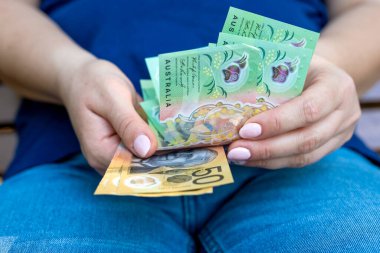 Kadın yeni 50 AUD Avustralya Doları finansal konseptini sayıyor. Kaydediliyor