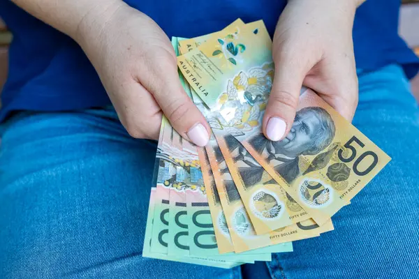 Kadın eli, Avustralya 'nın yüz elli dolarlık Avustralya Doları' nı tutuyor. Kaydetme kavramı
