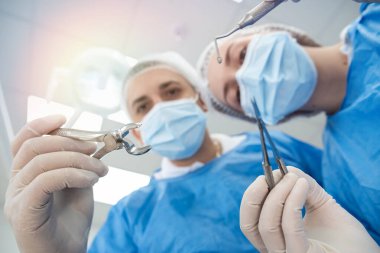 Bir grup doktor, dişçi kliniğinde ameliyat sırasında bir hastanın dişini çıkarıyor. Modern ameliyathane