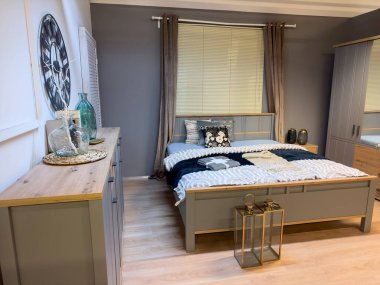 Şık bir yatak odası, geniş rahat bir yatak odası ve ahşap dolap. Ev ya da otel içi.