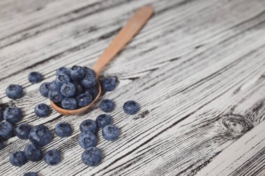Yaz dönemi. Tahta kaşıkta taze yaban mersini..