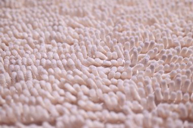Bath mat close-up. The texture of the carpet with a long and fluffy pile. The image is tinted pink. Shallow depth of field.