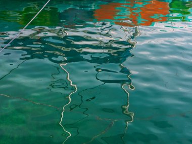 Boat and boat water reflexion in water. Abstract distorted boat elements in water. Blue water surface. Ripples reflex element in the lake Garda. Mirroring wave background. Abstract turquoise texture. clipart