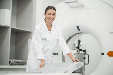 Duruşmadan önce. Uzun saçlı doktor MRI tarayıcısını işe hazırlıyor.