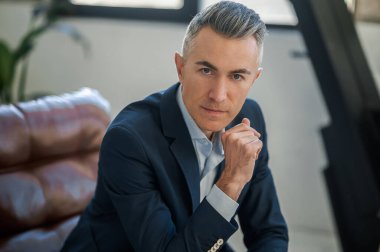 Ofiste. Ofiste oturan takım elbiseli bir iş adamı.