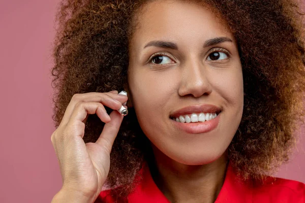 Słuchawki Bezprzewodowe Młoda Kobieta Używa Bezprzewodowych Słuchawek Wygląda Zadowoloną — Zdjęcie stockowe